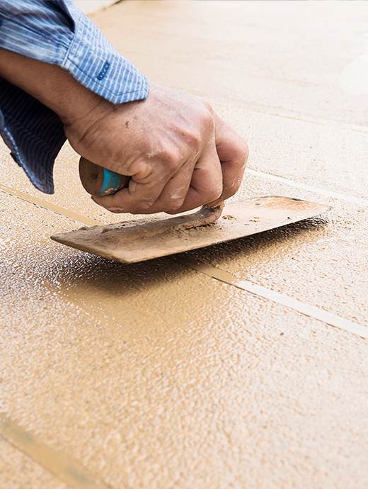 Close-up of a person in Oregon skillfully smoothing wet concrete with a trowel, perfecting the surface for an advanced concrete coating.