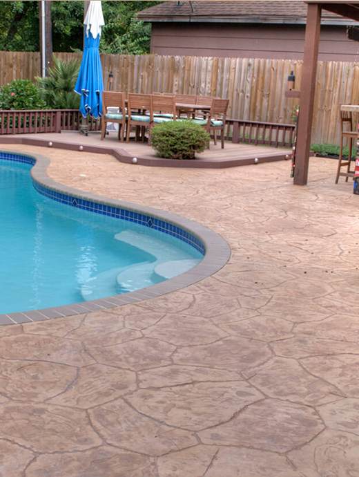 The backyard boasts a serene swimming pool surrounded by a stamped concrete deck with premium concrete coating, perfect for durability. Relax on the patio furniture under the shade of an umbrella, all enclosed by a charming wooden fence reminiscent of Oregon's rustic charm.